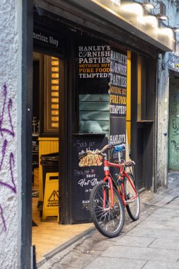 Sabahın erken saatlerinde tapınak barının duvarına yaslanan kırmızı bisiklet, İrlandalı ünlü barlar, kentsel ve sokak fotoğrafçılığı, 17 / 01 / 2022, Dublin, İrlanda