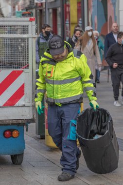 Sokaktan çöp toplayan belediye çalışanı, çöp, çöp kutusu, Grafton Caddesi, sokak fotoğrafçılığı, 08 / 01 / 2022, Dublin, İrlanda