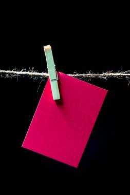 A jute clothesline, clothes pegs(clips), and a blank pinkish color note card to convey a message, which could be a love note or an inspirational quotations ideal for Valentine, a reminder, a one liner