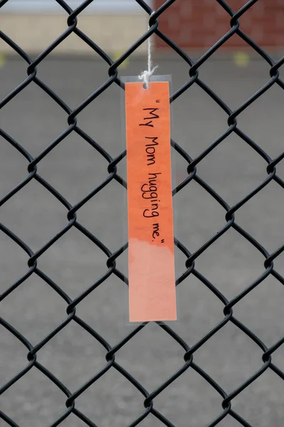 Laminated Note Card Mother Hugging Hanging Chain Link Fence School — стоковое фото