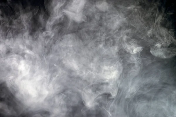 A white smoke cloud on a black background, photo could be used as a background, smoke texture or abstract - stock Photography