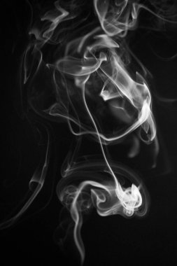 Siyah arka planda siyah ve beyaz kıvrımlı, yükselen bir duman deseni, fotoğraf arka plan, duman dokusu, soyut veya genel stok fotoğrafçılığı olarak kullanılabilir..