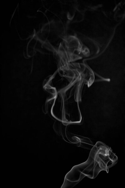 Black and white swirling, ascending smoke pattern on a black background, photo could be used as a background, smoke texture, abstract, or general stock photography.