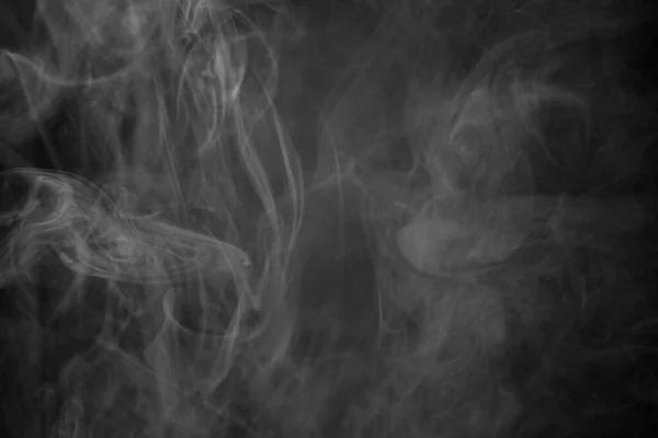 A black and white shot of a smoke cloud against a black background, photo could be used as a background, smoke texture or abstract - stock Photography