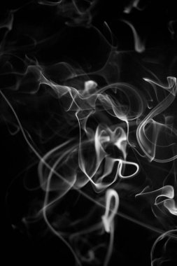 Siyah arka planda sarımsı altın rengi olan kıvrımlı, yükselen bir duman deseni, arka plan, duman dokusu veya soyut veya genel stok fotoğrafçılığı olarak kullanılabilir..