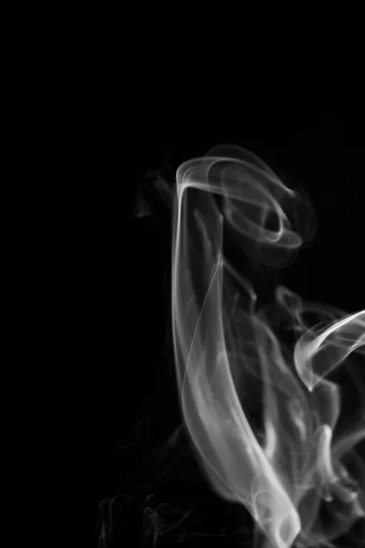 A black and white swirling, ascending smoke pattern on a black background, photo could be used as a background, smoke texture, abstract, or general stock photography.