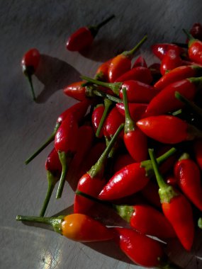 Resim küçük, kırmızı, çok sıcak ve baharatlı biber yığınını gösteriyor.