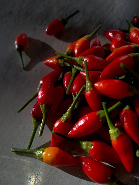 Resim küçük, kırmızı, çok sıcak ve baharatlı biber yığınını gösteriyor.