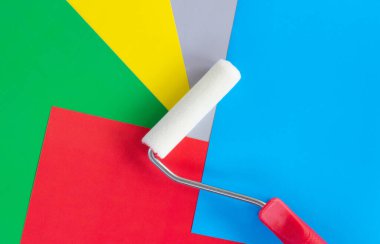 Yeşil kırmızı mavi arka planda düz bir boya silindiri var.