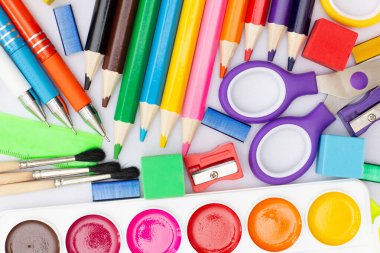 Okul malzemeleriyle bembeyaz ahşap arka planda düz kompozisyon, kalemler kauçuk fırça.