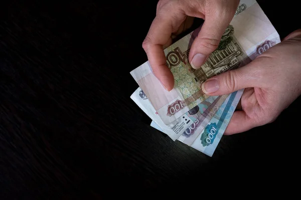Vrouwelijke Hand Houdt Een Bundel Bankbiljetten Russische Roebel Close Zwarte Rechtenvrije Stockfoto's