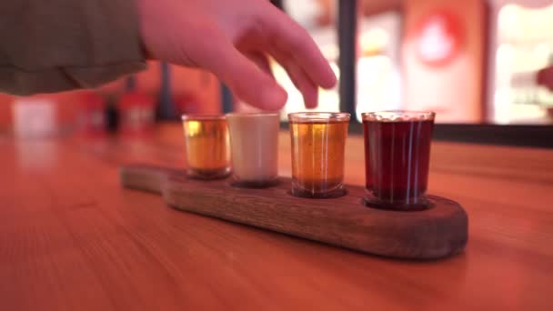 Männliche Hand nimmt ein Glas stark alkoholischen Getränks von einem Holzständer. Verantwortungsbewusstes Trinken. Getränkeverkostung. — Stockvideo