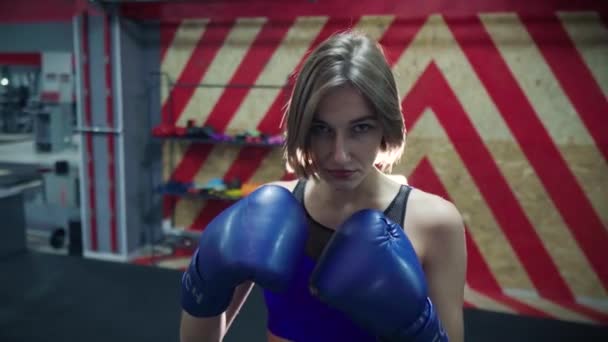 Porträtt av attraktiv kvinna. Sport modell i boxningshandskar poserar framför kameran. Fitness flicka i gymmet. — Stockvideo