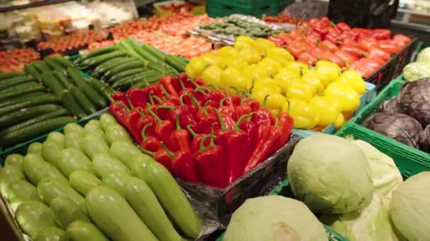Багато різних овочів виставлено в магазині. Роздрібна торгівля продовольчими товарами в супермаркеті. Плавна панель камери . — стокове відео