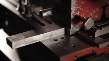 Fabrikada metal işçiliği. Metal ürünlerin özel bir makineyle üretilmesi. Özel bir makinenin metal kesimi. El yapımı demir tabaklar..