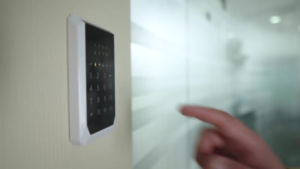 壁のキーボードを使用して部屋のスマートセキュリティシステムをオフにします。日常生活における近代的な技術。デバイスのタッチボタンを押す. — ストック動画