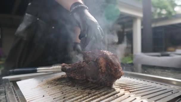 En stor tomahawkbiff på en restaurang. Kocken i svarta handskar förbereder en utsökt bit grillat kött. Sällsynt saftigt nötkött. — Stockvideo