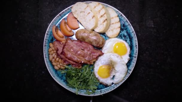 Sült tojás szalonnával, pirítóssal és zöldséggel. Forgó kaja. Egészséges táplálék. Tökéletes reggeli. Bemutatása éttermi étel gyönyörű elegáns tányéron. Egy kulináris remekmű bemutatása. — Stock videók