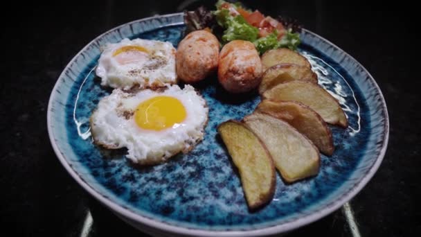 Gebakken eieren met worstjes, toast en groenten. Roterend voedsel. Dieet gezond voedsel. Perfect ontbijt. Presentatie van een restaurantschotel in prachtig stijlvol bord. Een culinair meesterwerk tonen. — Stockvideo