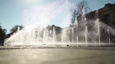 Şehirdeki sokak çeşmesi yakın plan. Su topraktan geliyor. Şehir hayatı. Rahatlatıcı tefekkür.