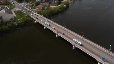 Nehrin üzerindeki köprü şehir manzaralı. Yollarda trafik vardı. Yoldaki arabanın yüksekliğinden takip ediliyor. Otobanda trafik sıkışık..