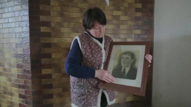 60 'lı yaşlardaki yaşlı bir kadın, eski bir atasının portresini siliyor. Rahat evinde nostaljik bir anıya sahip bir kadın. Sıradan bir yaşlı hayatı ve buruşuk bir el derisi. Biyografi, anılar veya tarih kavramı