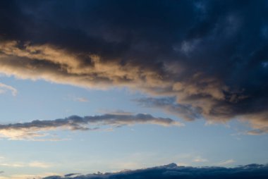 Mavi gökyüzünde koyu ağır bulutlar. Yaz, güneş.