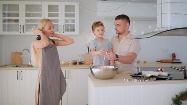 Anya és apa megtanítja a fiuknak, hogyan kell mézeskalácsot és karácsonyi sütit csinálni.. — Stock videók