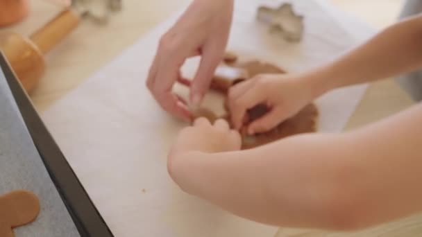 Маленький хлопчик вирізає печиво з тіста і кладе на піднос для печі з батьком . — стокове відео
