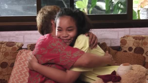 Matka rozmawia z córką siedząc na kanapie i przytulając się do siebie — Wideo stockowe
