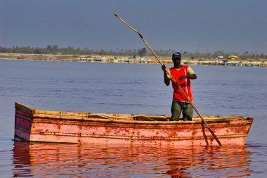 SENEGAL, AFRICA - MARSCH Circa, 2016. Kimliği belirsiz siyah Afrikalı kadın ve erkek Senegal 'deki Pembe Göl' de çiftçinin denizden tuz almaya geldiği yerde. Çok zor bir iş. Canlı renkler