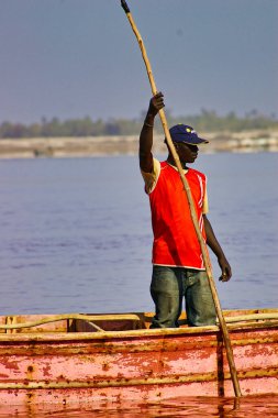 SENEGAL, AFRICA - MARSCH Circa, 2016. Kimliği belirsiz siyah Afrikalı kadın ve erkek Senegal 'deki Pembe Göl' de çiftçinin denizden tuz almaya geldiği yerde. Çok zor bir iş. Canlı renkler