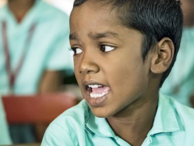 Puducherry, Hindistan-Aralık Circa, 2018. Sınıfta yeşil hükümet üniformanla konuşan bilinmeyen Zavallı Hintli çocuk portre