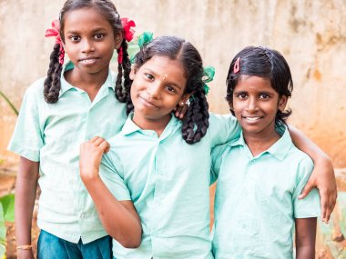 Puducherry, Hindistan - Aralık yaklaşık, 2018. Kimliği belirsiz en iyi çocuk kız arkadaş sınıf ile ayakta gülümseyen hükümet okul üniformalı omzuna elini. Dostluk zevk çok ırklı schoolchilds portresi.