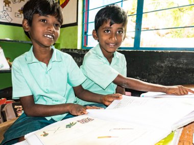 Puducherry, Hindistan - Aralık yaklaşık, 2018. Kimliği belirsiz mutlu öğrenciler sınıf okuma eğitimi hükümet okul üniformalı kitaplar kapalı sınıf İngilizce. Okul zavallı gençler sivil toplum yardım için gülümseyen portresi