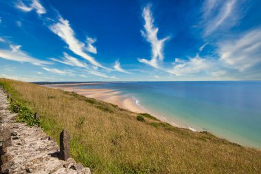 Bulutlu gökyüzü ve doymuş renklerle sahnenin manzarası. Altın saat kum tepeciği, çimen okyanus manzarası. Cotentin Carteret Manche Fransa 'da güzel bir sahil..