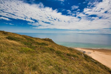Bulutlu gökyüzü ve doymuş renklerle sahnenin manzarası. Altın saat kum tepeciği, çimen okyanus manzarası. Cotentin Carteret Manche Fransa 'da güzel bir sahil..