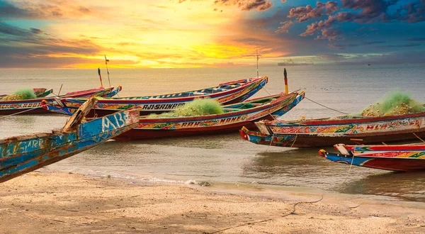 SALY, MBour, SENeGAL - 20222 yılı dolayları. Pirogue botlarıyla sahilde harika bir gün batımı. Seyahat turizm beldesi. Atlantik Okyanusu