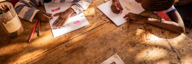 Bour, Senegal - Aralık 2021 civarı. Avrupa STK 'sı ona okul ve aile yemeği ödemesinde yardım ettiği için vaftiz babası veya vaftiz anasına mektup yazan kimliği belirsiz genç bir çocuk. Ellere yakın çekim