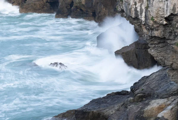 waves crashing against the cliffs in the sea. High quality photo