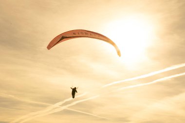 paraglider gliding over the mountains under sunset sky. High quality photo