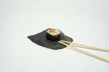 Beyaz arka planda yemek çubukları olan bir parça shushi. Yüksek kalite fotoğraf