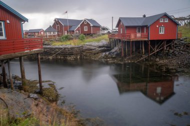 Norveç 'in Lofoten Adaları' ndaki balıkçı köyünde bir balıkçı kulübesi. Arkaplanda dağlar