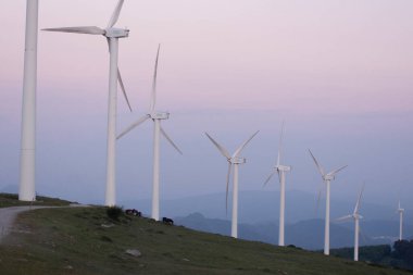 Ekolik rüzgar jeneratörleri gün batımında dağlarda dönüyorlar. Yüksek kalite fotoğraf