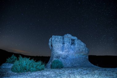 Gece yıldızlarının altında ilginç taş oluşumları. Yüksek kalite fotoğraf