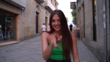 İspanya sokaklarında yürüyen güzel bir kız kameraya bakıyor ve gülümsüyor. Yüksek kalite 4k görüntü