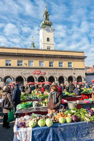 Zagreb Hırvatistan, yerel kadın saat kulesinin altında ev yapımı lahana, havuç ve diğer sebzeleri satıyor.