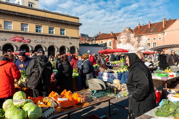 Zagreb Hırvatistan ve Dolac 'ın ünlü pazarındaki kalabalık taze organik sebze satın alıyor. Yerel bir kadın lahana ve kabak satıyor..