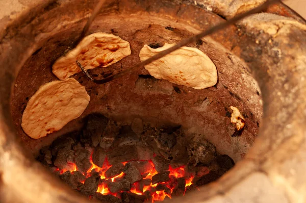 Geleneksel Hint Tandır kil fırınından çiğ veya roti düz ekmek çıkartılıyor