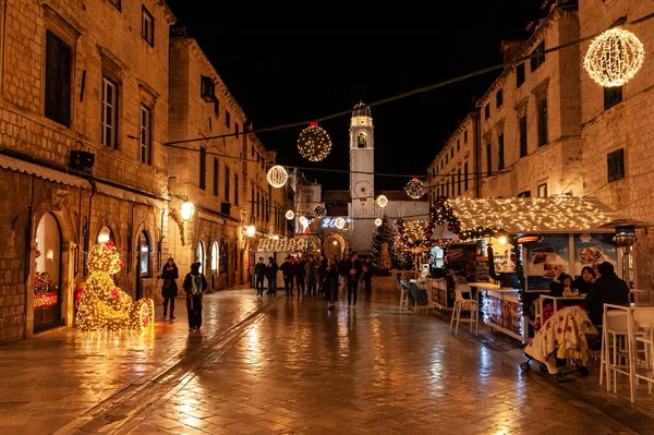 Noel gezginleri gece Dubrovnik Eski Kasabası 'nda dekorasyon ve Noel ikramiyelerinin keyfini çıkarıyorlar.